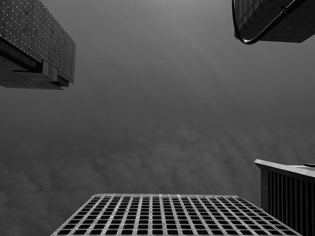 a black and white photo of skyscrapers against a cloudy sky