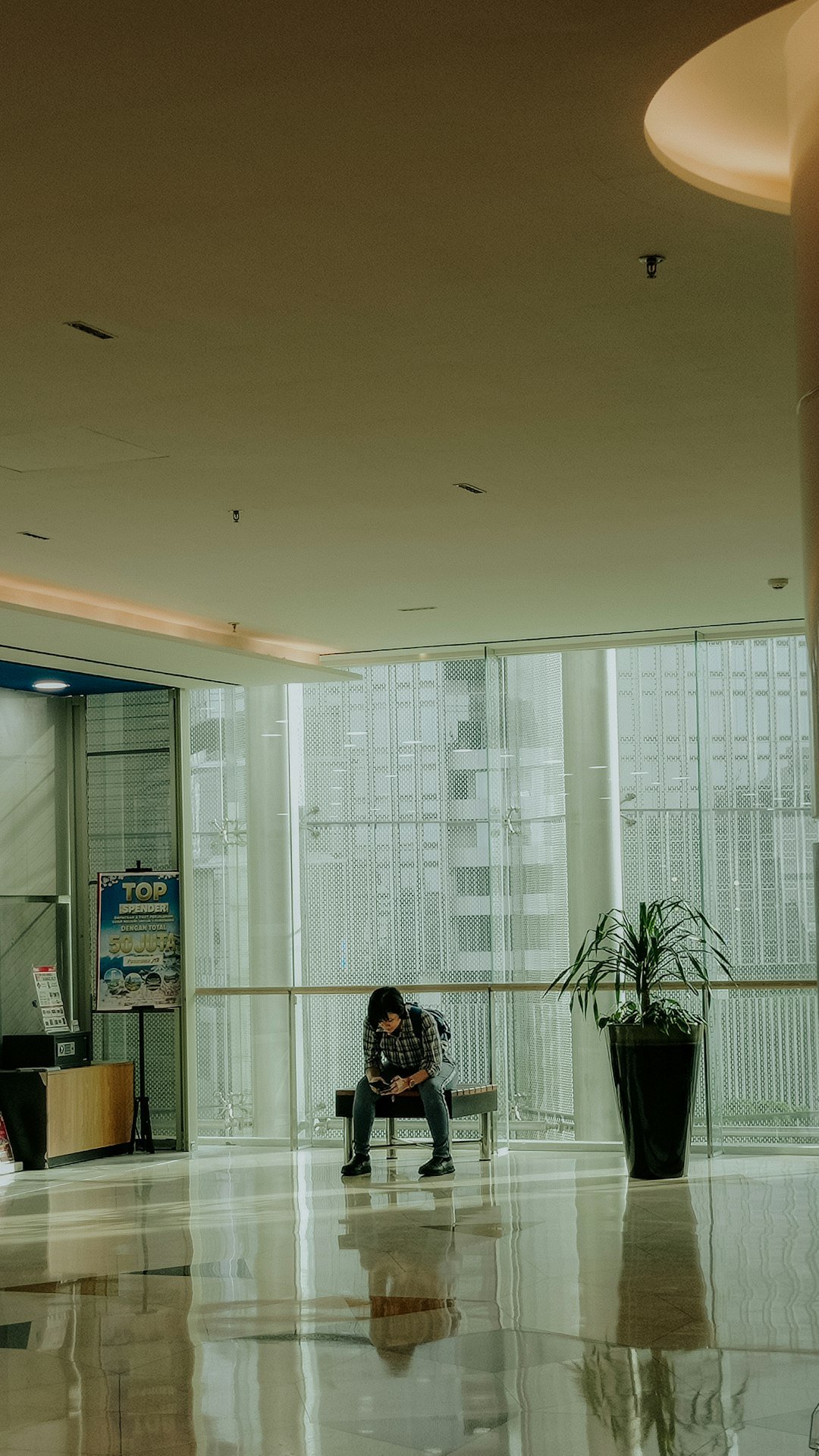 A person sits alone, looking at their phone.