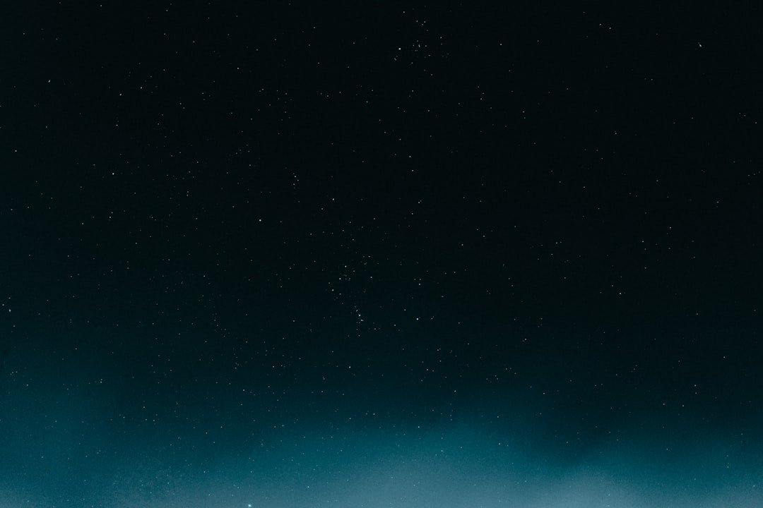 a man standing on a snow covered slope under a dark sky