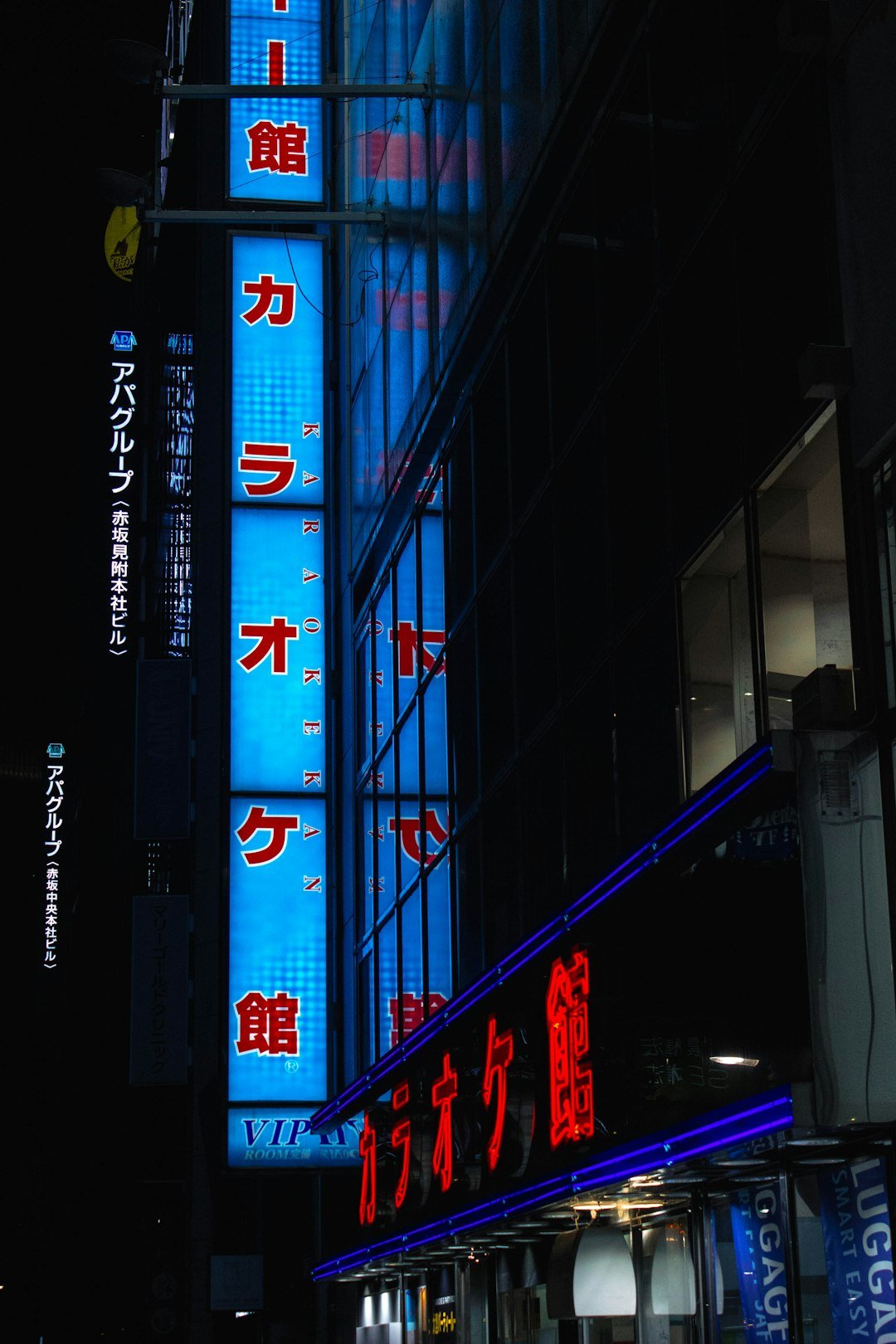 A city street at night with tall buildings