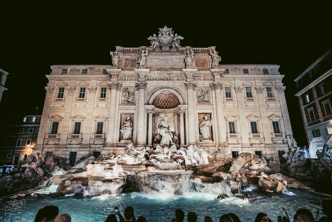 a group of people standing in front of a fountain